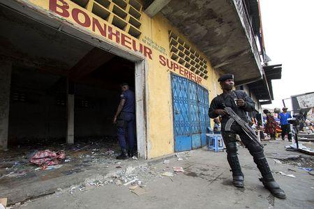 A police officer stands guard in front of a store that was looted during violent protests in Kinshasa, Democratic Republic of Congo January 23, 2015. REUTERS/Rey Byhre
