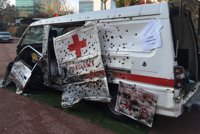 A display outside the International Conference of the Red Cross and Red Crescent in Geneva shows an ambulance that has been attacked. States at the meeting adopted a resolution vowing to protect healthcare workers. Photo: Heba Aly/IRIN.