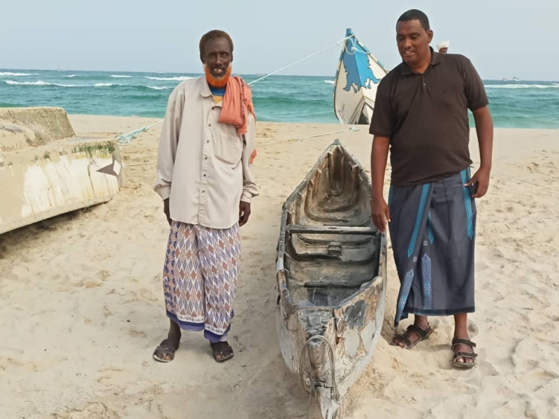 Khalif with a fisherman and his skiff.